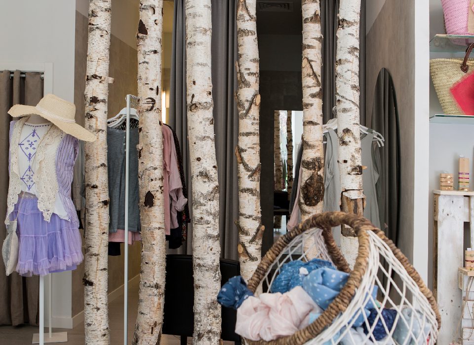 decoración tienda ropa moda con troncos árboles