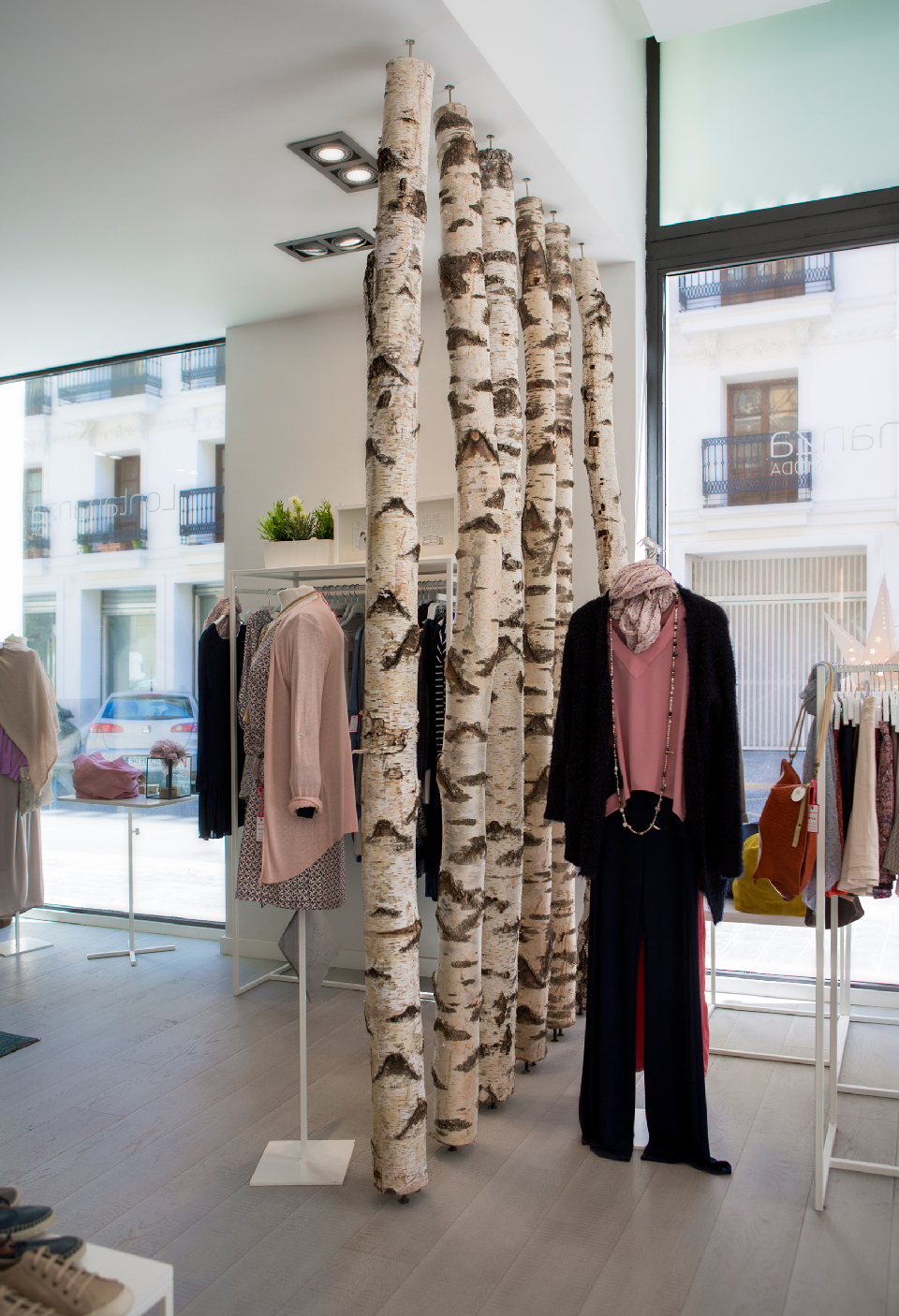 decoración tienda ropa moda con troncos árboles